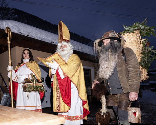 Heiliger Nikolaus mit einem Engel und Perchten. Brauchtum in Österreich. 